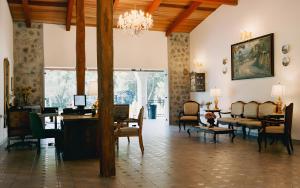 a living room with a chandelier and a table and chairs at Hotel Boutique El Rosario in Teapa
