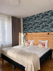 a bedroom with a large bed with a floral wall at Hotel Falun in Falun