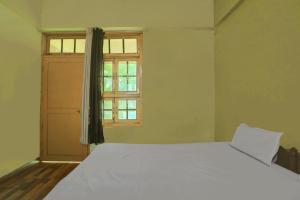 a bedroom with a large white bed and a window at Hotel O AP Hotel in Sitāpur
