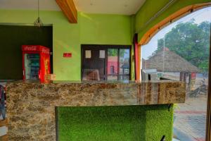 a counter in a restaurant with a coke machine and a phone booth at Hotel O AP Hotel in Sitāpur