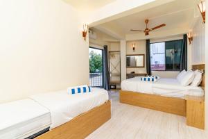 a bedroom with two beds and a balcony at White Sand Maldives in Ukulhas +47 photos