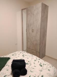a bed with two black towels on it with a door at חלון לגליל העליון in Beit Hillel