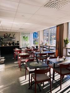 a restaurant with tables and chairs and windows at Hotel Falun in Falun