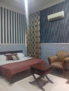 a bedroom with a bed and a table and a chair at Andweruth Residences in Abuja