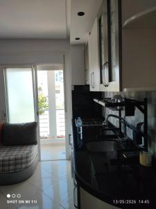 a kitchen with a black counter top and a couch at Isco Stam in Martil