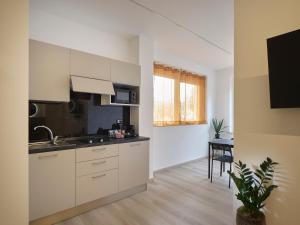 a kitchen with white cabinets and a table in a room at Palazzo house in Palazzo