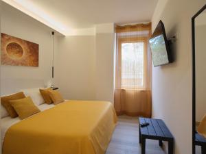 a bedroom with a yellow bed and a window at Palazzo house in Palazzo