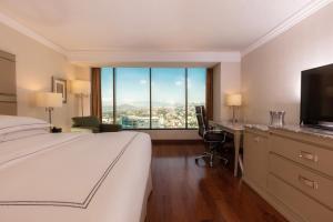 a hotel room with a bed and a desk and a window at Barcelo Guadalajara in Guadalajara +66 photos