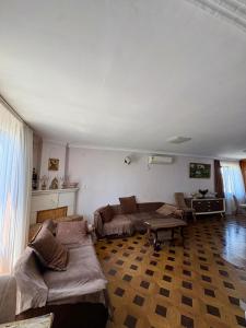 a living room with a couch and a table at Qobuleti, Rustaveli street 162 e in Itʼkhvisi +8 photos