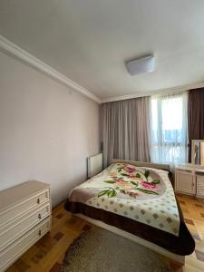 a bedroom with a bed and a dresser in it at Qobuleti, Rustaveli street 162 e in Itʼkhvisi