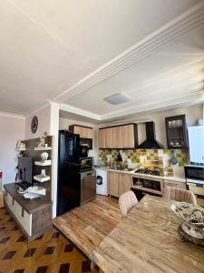 a kitchen with a wooden table and a black refrigerator at Qobuleti, Rustaveli street 162 e in Itʼkhvisi