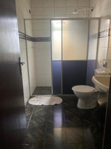 a bathroom with a shower and a toilet and a sink at Pousada Ponta Grossa in Ponta Grossa +7 photos