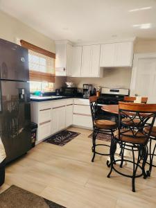 a kitchen with white cabinets and a table and chairs at Jadens Guest House - by ZenBreak in Saint Michael