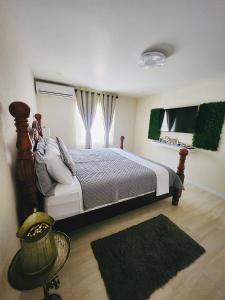 a bedroom with a large bed and a window at Jadens Guest House - by ZenBreak in Saint Michael