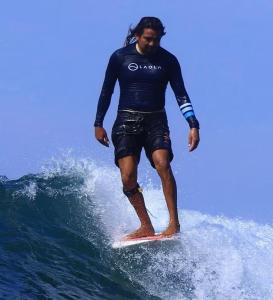 a man riding a wave on a surfboard in the ocean at Laola Surf Residence in El Sunzal