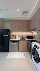 a kitchen with a black refrigerator and a dishwasher at Inter Home Coral - beach access in Ras al Khaimah