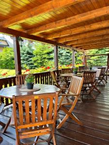 a wooden table and chairs on a wooden deck at Penzion pod Šerákem - celý objekt Ostružná - Jeseníky in Ostružná