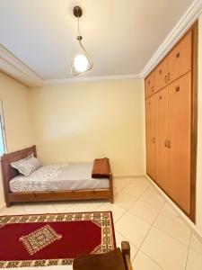 a bedroom with a bed and a cabinet and a rug at Assafa in Agadir +2 photos