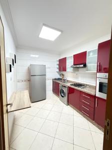 a kitchen with red cabinets and a stainless steel refrigerator at Assafa in Agadir