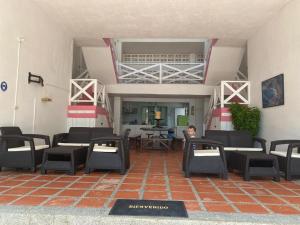 a person sitting in a room with chairs and a table at Hotel Miramar Capurganá Casa de playa in Capurganá
