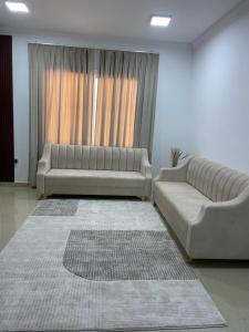 a living room with a couch and a large window at شقق مفروشة in ‘Awqad Bayt Marhūn