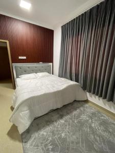 a bedroom with a bed and a large window at شقق مفروشة in ‘Awqad Bayt Marhūn