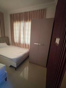 a small bedroom with two beds and a cabinet at شقق مفروشة in ‘Awqad Bayt Marhūn