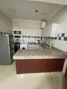 a kitchen with white cabinets and a counter top at شقق مفروشة in ‘Awqad Bayt Marhūn