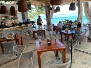 a restaurant with a bar and people sitting at tables at Maria's Kan Kin in Isla Mujeres