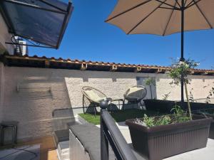 a patio with an umbrella and a table and chairs at Petra in Poreč