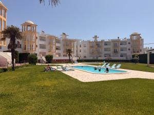 a group of people sitting around a swimming pool at Moinho do vento in Nazaré
