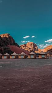 a row of buildings with mountains in the background at SaLem rum in Wadi Rum