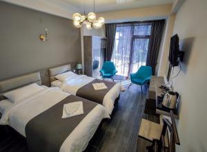 a hotel room with two beds and a television at Villa MD Grigoleti in Grigoleti