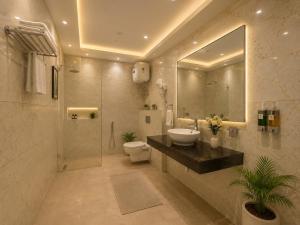 a bathroom with a sink and a toilet and a mirror at Hotel Decent Premier Suites Near Delhi Aerocity in New Delhi +59 photos
