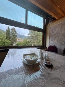 a bowl of food sitting on a table with a window at Khan House in Sheki