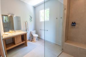 a bathroom with a shower and a sink and a toilet at Villa Costa Vida Tower Suites in Quepos +15 photos