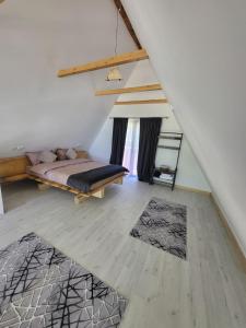 a bedroom with a bed and a wooden floor at Cabana Andi in Brebu