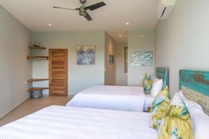 a bedroom with two beds and a ceiling fan at Villa Costa Vida Tower Suites in Quepos