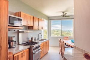 a kitchen with a stove and a dining room with a table at Villa Costa Vida Tower Suites in Quepos