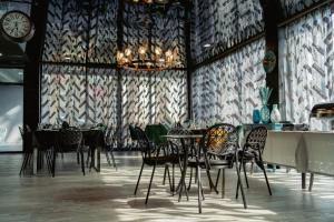 a dining room with tables and chairs and a clock at Villa MD Grigoleti in Grigoleti