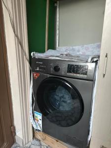 a washing machine in a room with a door at Khan House in Sheki