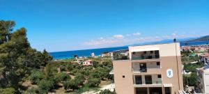 a building on a hill with the ocean in the background at Theasis 2 in Neos Marmaras