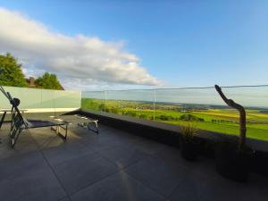 a balcony with a table and a view of the ocean at Morgenrot Panorama-Apartment 2 - Zwei Balkone in Gnotzheim
