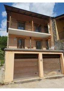 two garage doors in front of a house at Check-in casas Mesón Casa Cereza in El Run