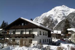 a building with a snow covered mountain in the background at Haus Hoher Sattel in Leutasch