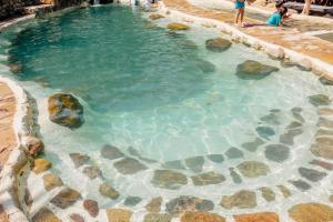 a pool of water with rocks and people in it at Güembé Hotel Lodge & Resort in Santa Cruz de la Sierra