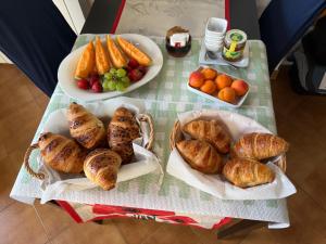 a table topped with plates of bread and pastries and fruit at BnB Dog and Friend in Rocchetta Tanaro