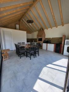 a kitchen and dining room with a table and chairs at Cabana Andi in Brebu