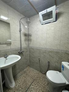a bathroom with a sink and a toilet and a microwave at Khan House in Sheki