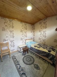 a bedroom with a bed and a table in a room at Khan House in Sheki